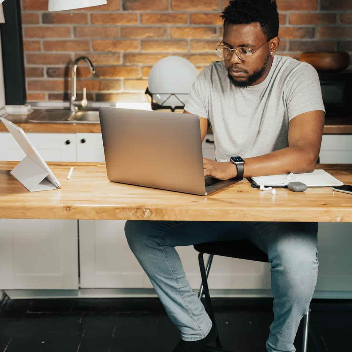 Man sitting at desk working on laptop.