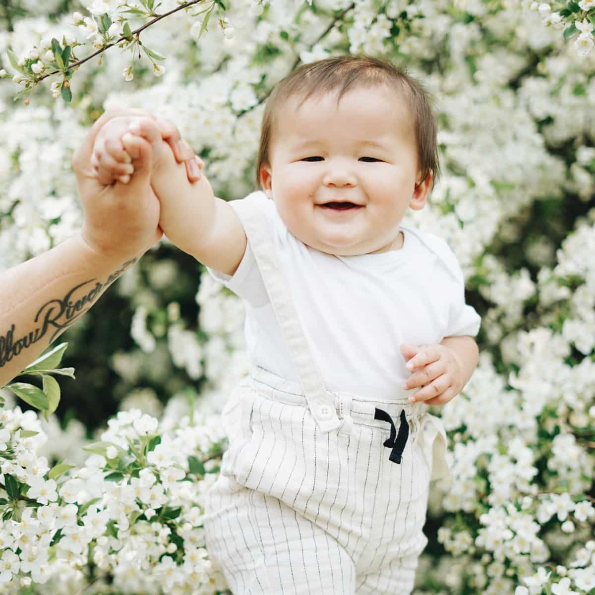 Baby walking through flowers.