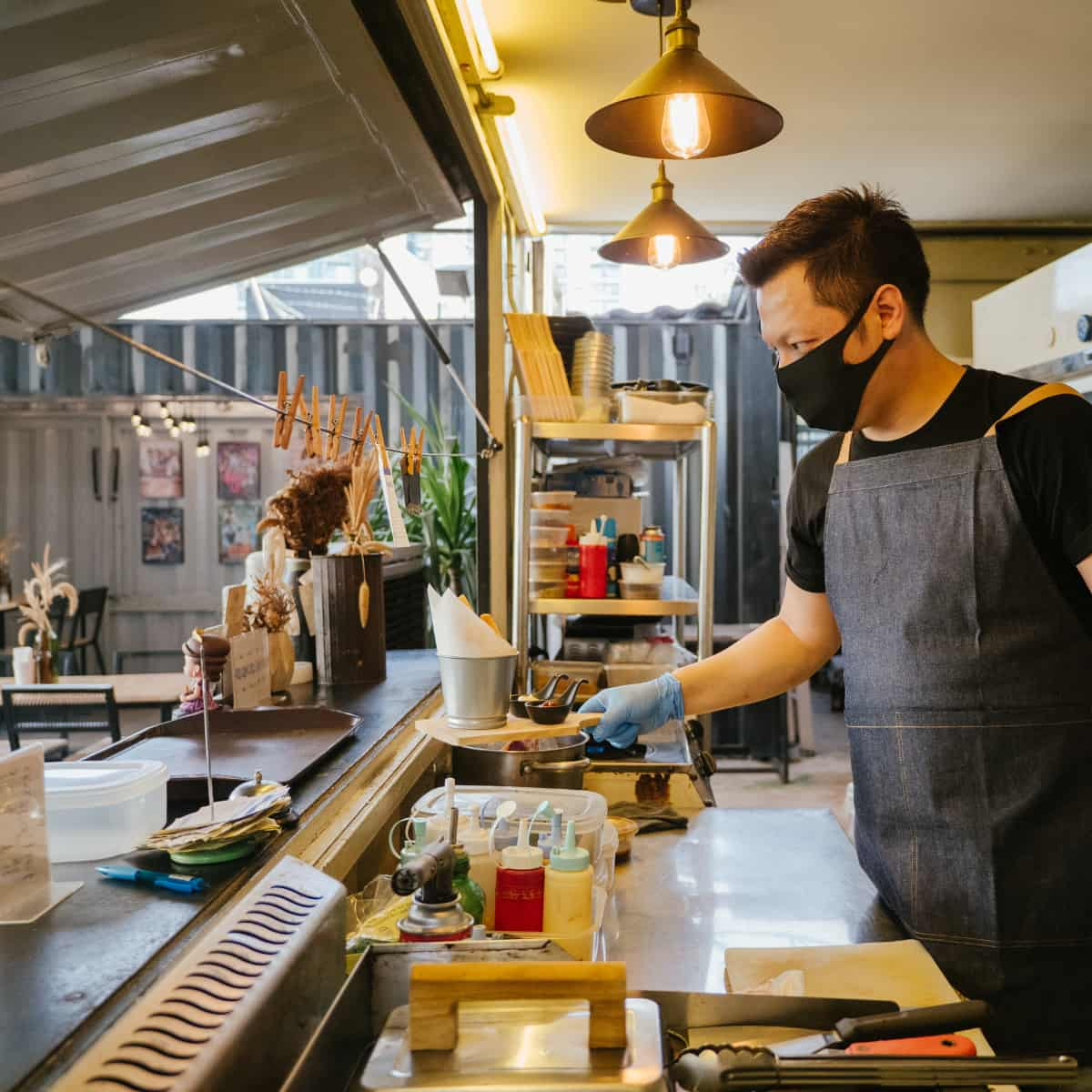 Man inside food truck cooking.