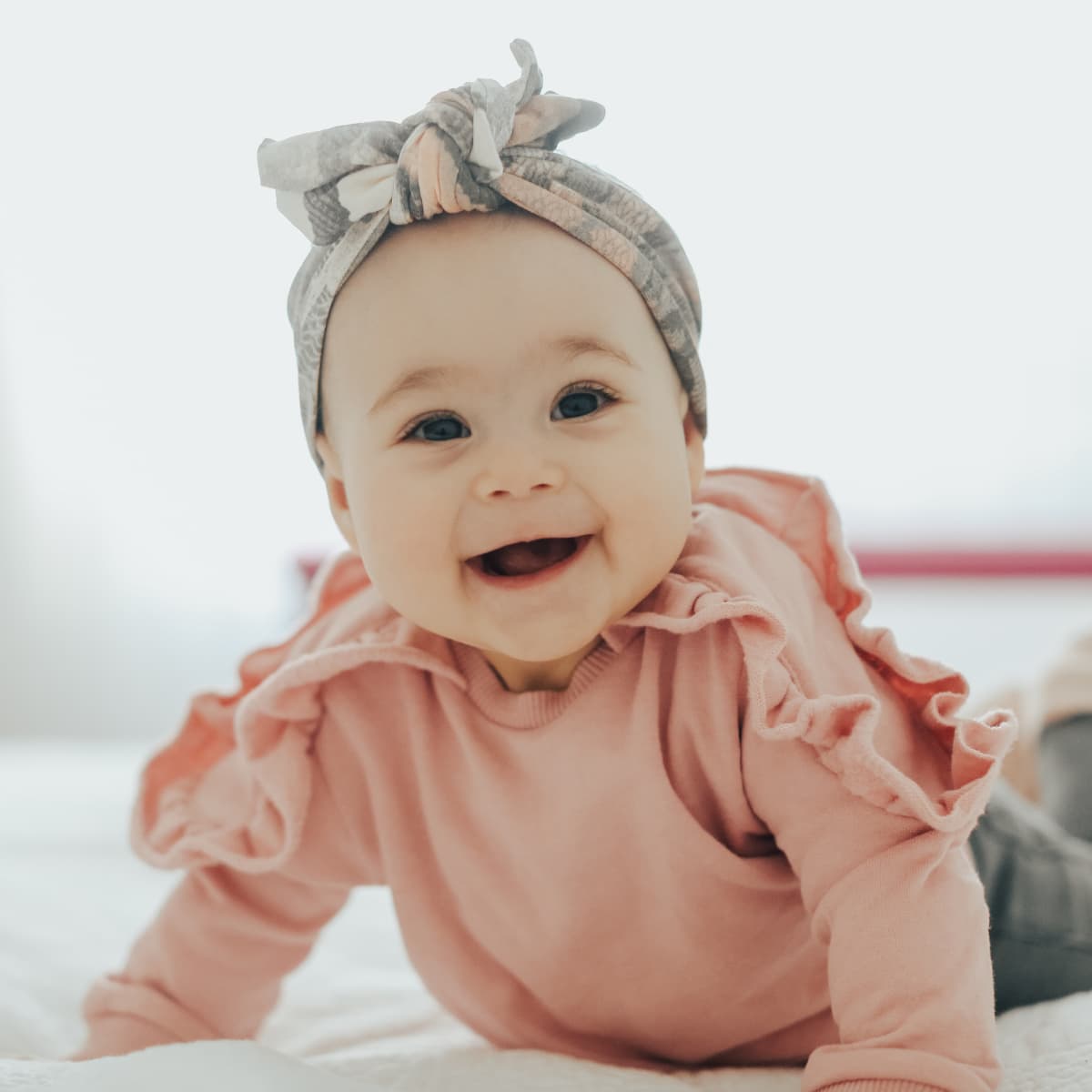 Happy baby crawling on bed.