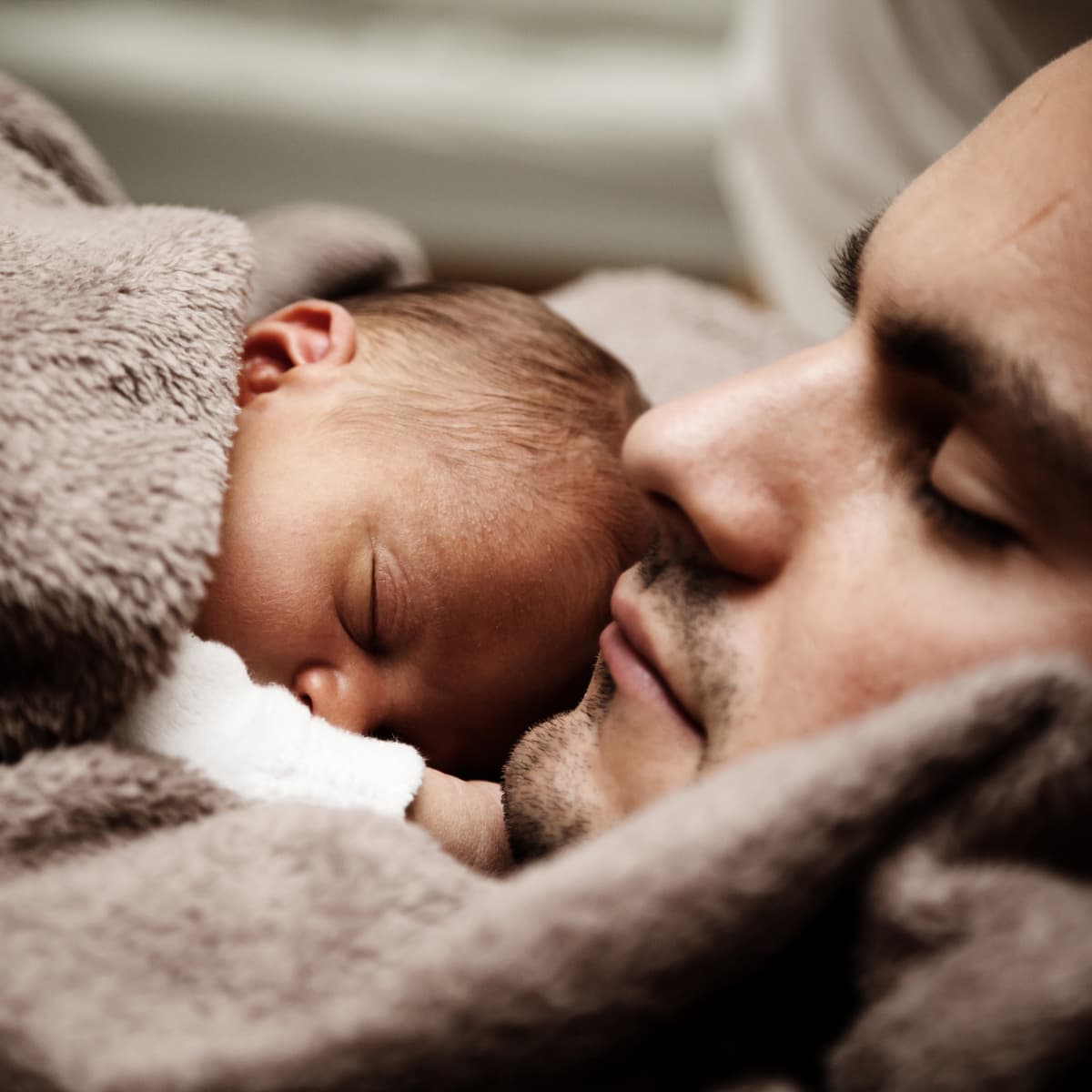 Father holding sleeping newborn.
