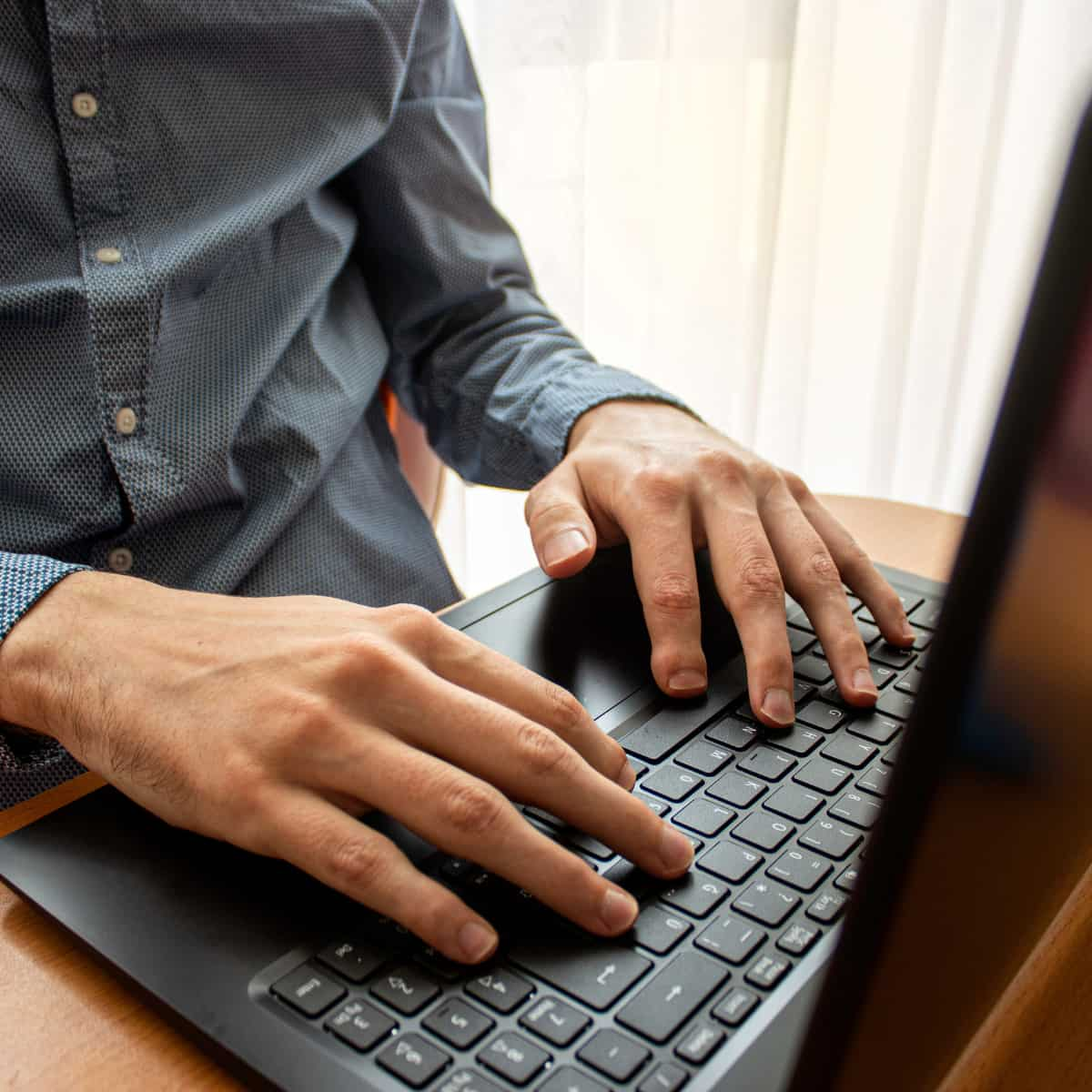 Man typing on keyboard.