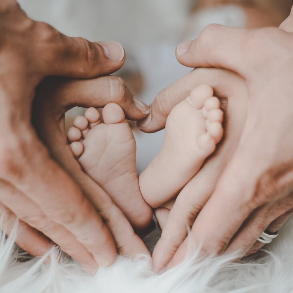 Parents holding baby's feet.