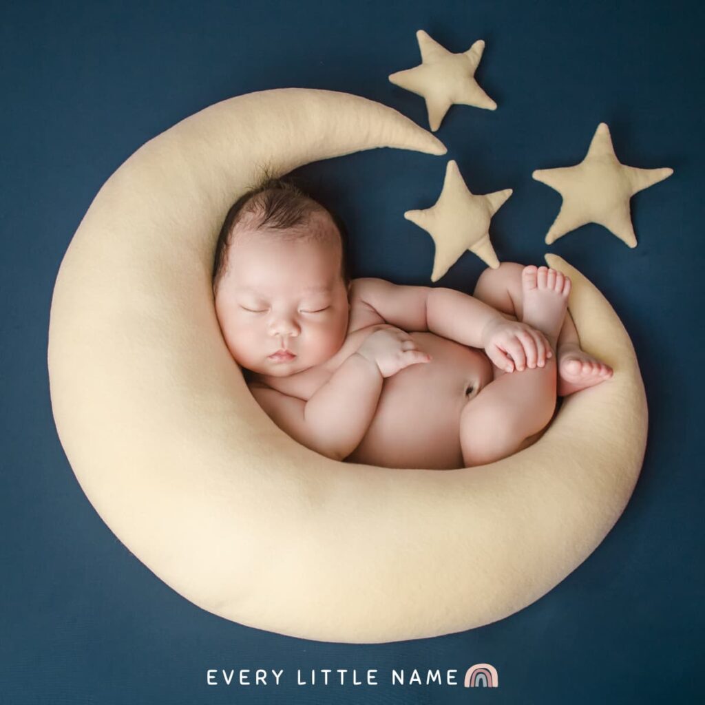 Newborn sleeping on moon and star pillow.